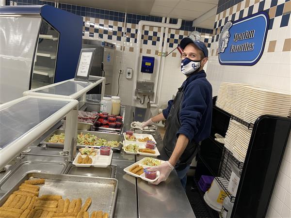 School nutrition employee behind a serving line